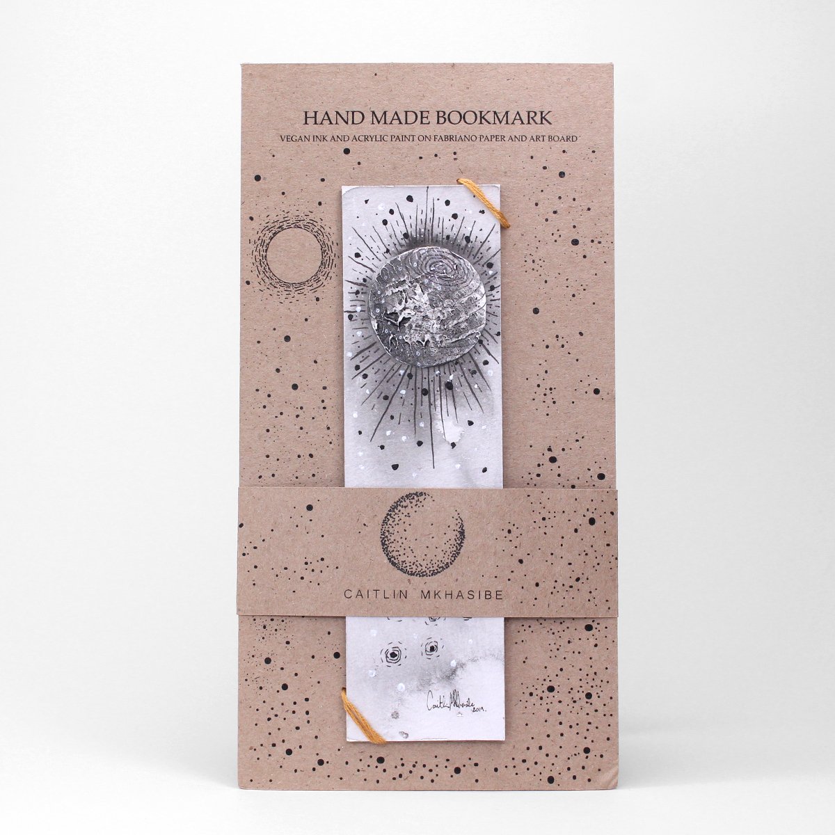Monochromatic, handmade, hand-painted bookmark with moon design and nude packaging. Made by Caiitlin Mkhasibe.