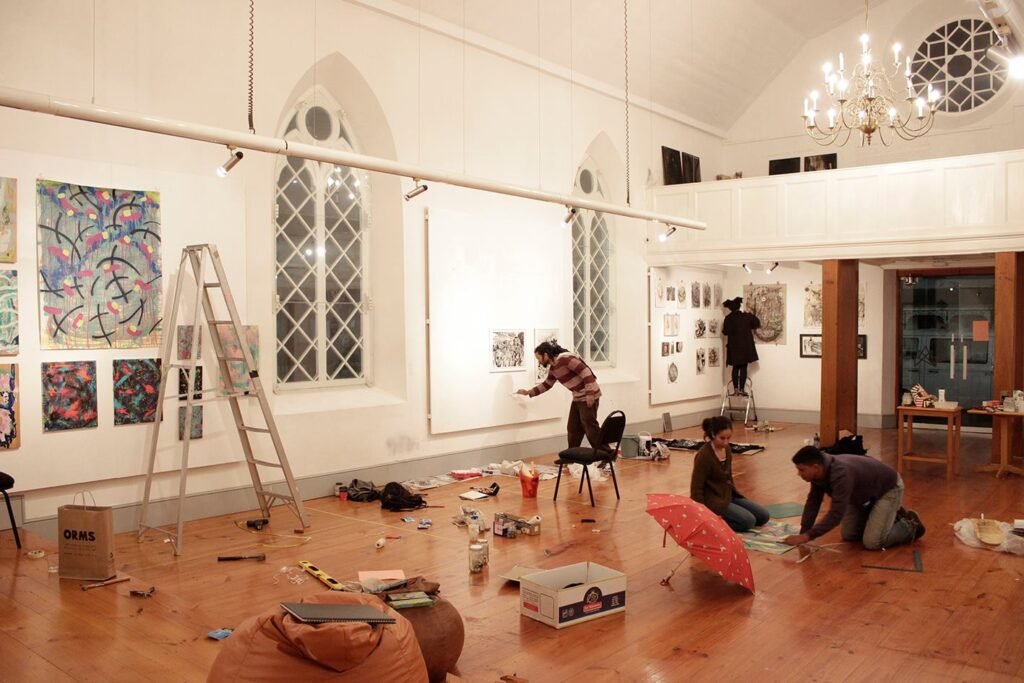 Exhibiting artists set-up their allocated walls for 'Untrammelled' exhibition at Gallery of the University of Stellenbosch (GUS). Image by Caitlin Mkhasibe